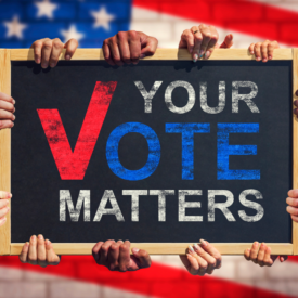 text: Your Vote Matter image: an american flag background with a chalkboard held up by many hands with the words